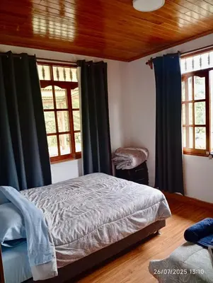 a bedroom with a bed and two windows at Casa de Campo in Chontabamba