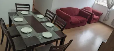 a dining room with a table and a red couch at Departamento 4p en condominio Centro de Lima in Lima