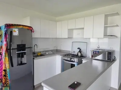 a kitchen with white cabinets and a stainless steel refrigerator at Casa de Playa en Puerto Viejo in Puerto Viejo