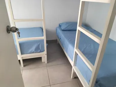 a small room with two bunk beds and a door at Casa de Playa en Puerto Viejo in Puerto Viejo
