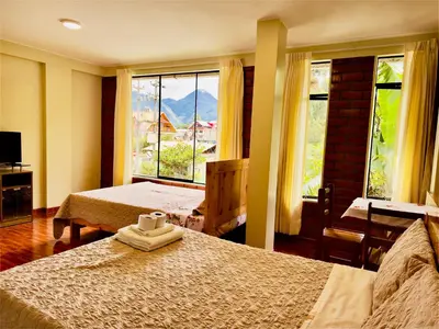 a bedroom with two beds and a large window at Casa Familiar TOVCA Oxapampa in Oxapampa