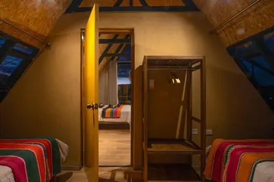 a room with two bunk beds and a mirror at Alpine Cabin Quito in Cusco