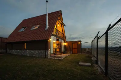 a house with a fence in front of it at Alpine Cabin Quito in Cusco