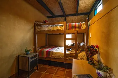 a bedroom with two bunk beds and a table at Alpine Cabin Quito in Cusco