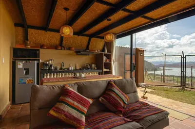 a living room with a couch and a large window at Alpine Cabin Quito in Cusco
