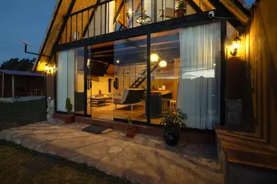 a house with a large glass window with a patio at Alpine Cabin Quito in Cusco