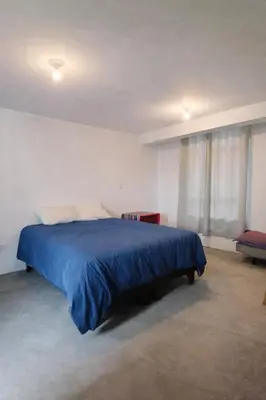a bedroom with a bed with a blue blanket at Posada El Pino