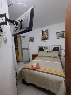 a bedroom with a bed with a tv on the wall at Hostal la familia in Churín