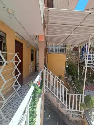 a building with a porch and a white railing at Hostal la familia in Churín