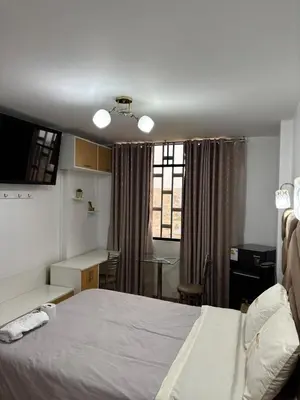 a bedroom with a bed and a desk and a table at Hospedaje Ariana in Supe