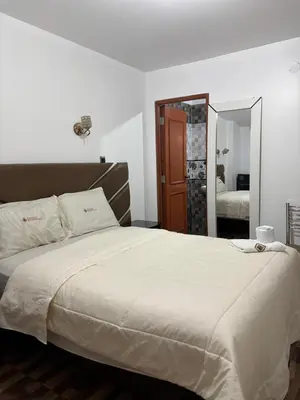 a bedroom with a large bed with a large mirror at Hospedaje Ariana in Supe