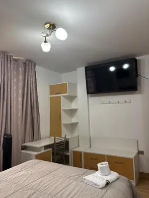 a bedroom with a bed and a desk with a television on the wall at Hospedaje Ariana in Supe