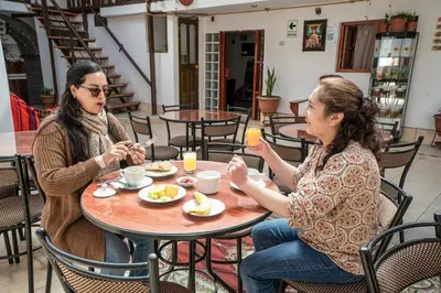 two women sitting at a table eating food at Horizonte Hotels in Cusco