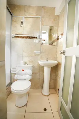 a small bathroom with a toilet and a sink at Horizonte Hotels in Cusco