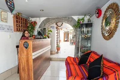 a woman standing behind a counter in a bar at Horizonte Hotels in Cusco