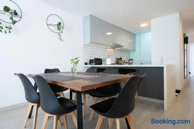 a kitchen with a wooden table and black chairs at Barranco-Miraflores 2BR OceanView Modern Apt up to 6 guests! in Lima