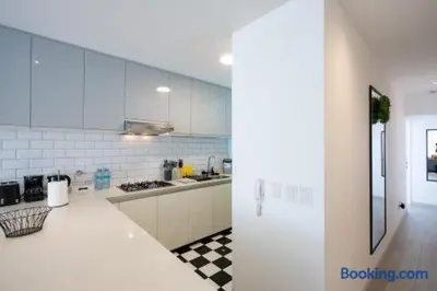 a white kitchen with a black and white checkered floor at Barranco-Miraflores 2BR OceanView Modern Apt up to 6 guests! in Lima