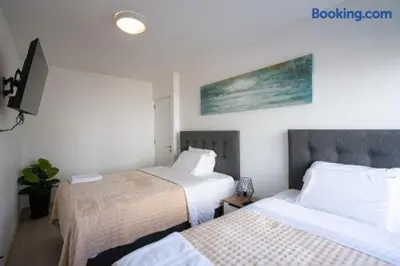 a hotel room with two beds and a tv at Barranco-Miraflores 2BR OceanView Modern Apt up to 6 guests! in Lima