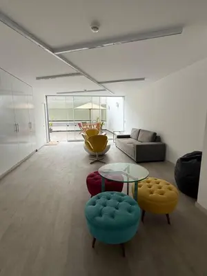 a living room with a glass table and twoools at Barranco-Miraflores 2BR OceanView Modern Apt up to 6 guests! in Lima
