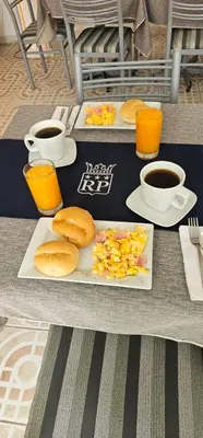 two plates of food on a table with cups of coffee at HOTEL Regency Plaza in Pisco