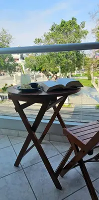 a wooden table with an open book on a balcony at HOTEL Regency Plaza in Pisco
