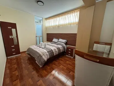 a bedroom with a bed and a wooden floor at Gran Hotel Real in Huancayo