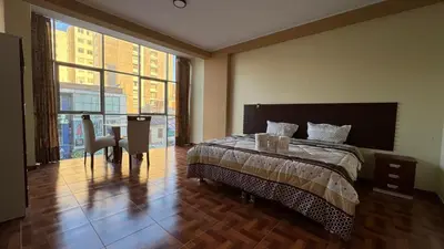 a bedroom with a bed and a desk and a window at Gran Hotel Real in Huancayo