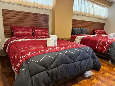 two beds in a room with red and black at Gran Hotel Real in Huancayo