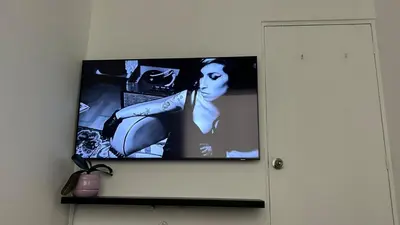 a television on a wall with a picture of a woman at Spacious and bright apartment with a beautiful view in Lima