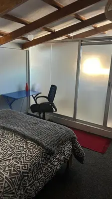 a bedroom with a bed and a desk and a chair at Cozy room with kitchenette and private bathroom in Cusco