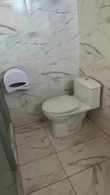 a bathroom with a toilet and a marble wall at Cozy room with kitchenette and private bathroom in Cusco