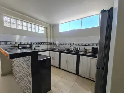 a large kitchen with white cabinets and a large window at comfortable magic apartment in San Juan Bautista