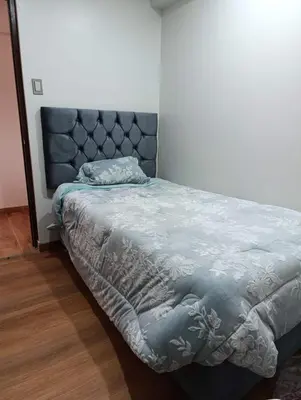 a bedroom with a bed with a blue comforter at Sumaq Sky in Cusco