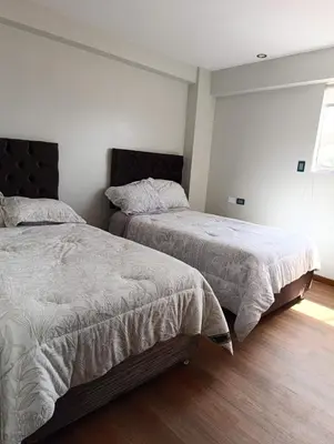 a bedroom with two beds and a window at Sumaq Sky in Cusco