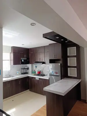 a kitchen with wooden cabinets and white appliances at Sumaq Sky in Cusco