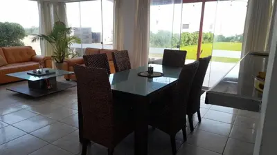 a dining room table and chairs in a living room at Casa frente al mar in Lurín