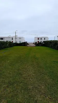 a large grassy field with buildings in the background at Casa frente al mar in Lurín
