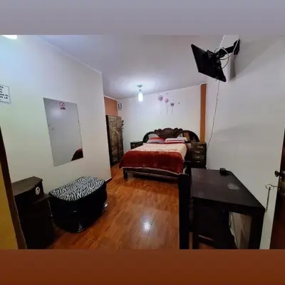 a bedroom with a bed and a table and a desk at Hospedaje secretos in Huancayo