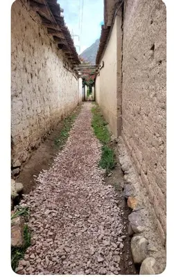 an alley between two buildings with a stone wall at Lavanda lodge Ollantaytambo in Ollantaytambo