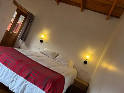 a bedroom with a bed with a red blanket at Lavanda lodge Ollantaytambo in Ollantaytambo