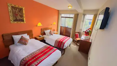 a hotel room with two beds and a flat screen tv at Hotel Boutique Imperial in Cusco
