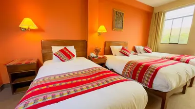 three beds in a room with orange walls at Hotel Boutique Imperial in Cusco