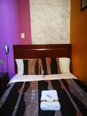 a bedroom with a bed with two towels on it at Hostal GQ in Lima
