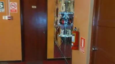 a glass display on a wall with a fire extinguisher at Hostal GQ in Lima