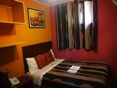 a small room with a bed and a window at Hostal GQ in Lima