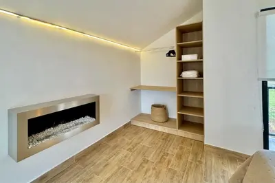 a living room with a fireplace and wooden floors at Tiny House con Jacuzzi, Fogata y Starlink in Anta