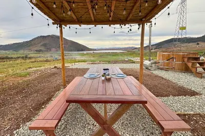 a wooden picnic table sitting on top of a field at Tiny House con Jacuzzi, Fogata y Starlink in Anta