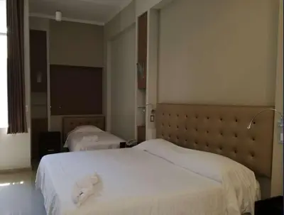 a hotel room with two beds and a flat screen tv at Hotel Cerro Azul in La Merced