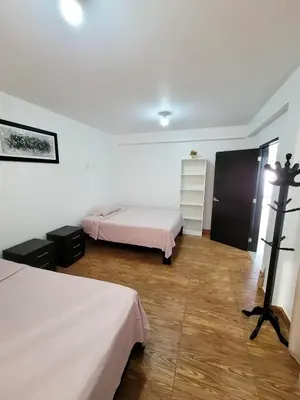 a bedroom with two beds and a wooden floor at Casa Bujama Playa y Piscina Privada in Bujama Baja