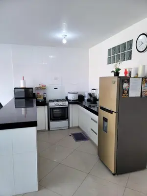 a kitchen with white cabinets and a stainless steel refrigerator at Casa Bujama Playa y Piscina Privada in Bujama Baja